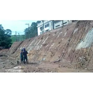 Talude rochoso alto com profissional trabalhando na base